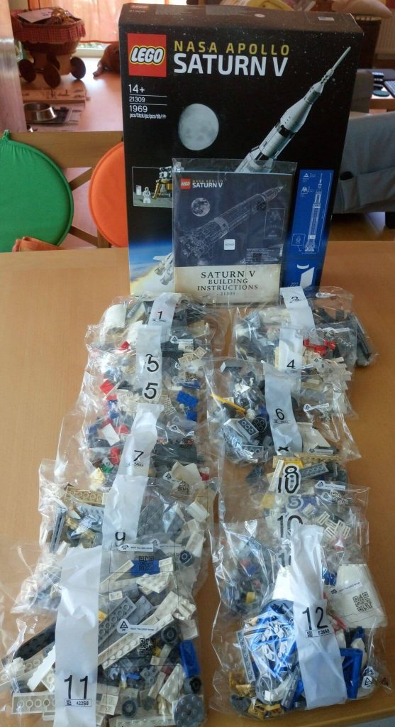 Der Packungsinhalt des Lego-Sets 21309: NASA Apollo Saturn V; 12 Beutel und eine dicke Anleitung