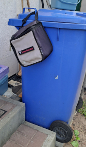 Unser Kacka-Container, der an der blauen Papiermüll-Tonne hängt